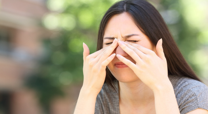 Woman with irritated eye due to poor air quality.